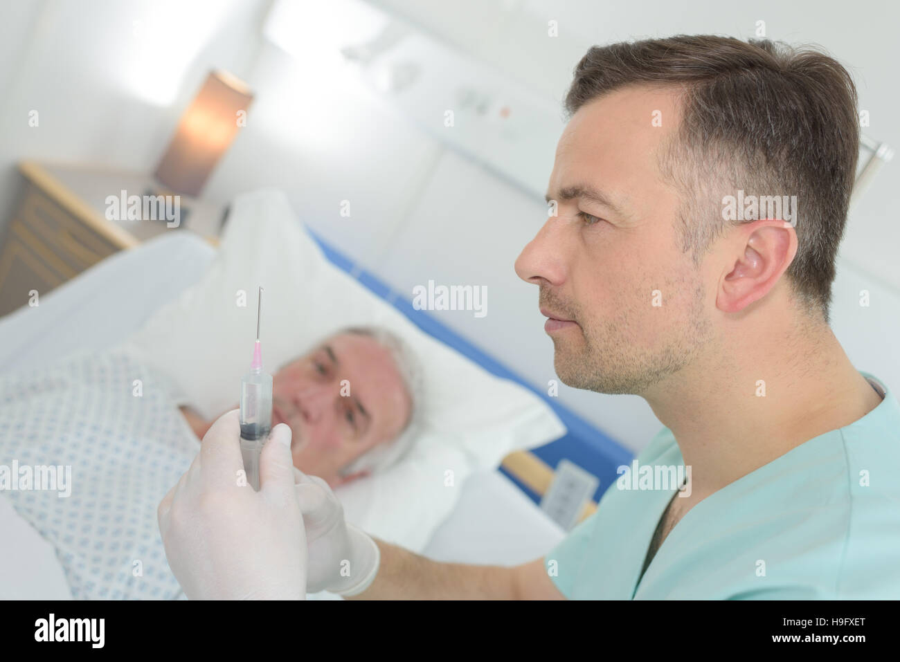 Medico dando una iniezione a un paziente maturo Foto Stock