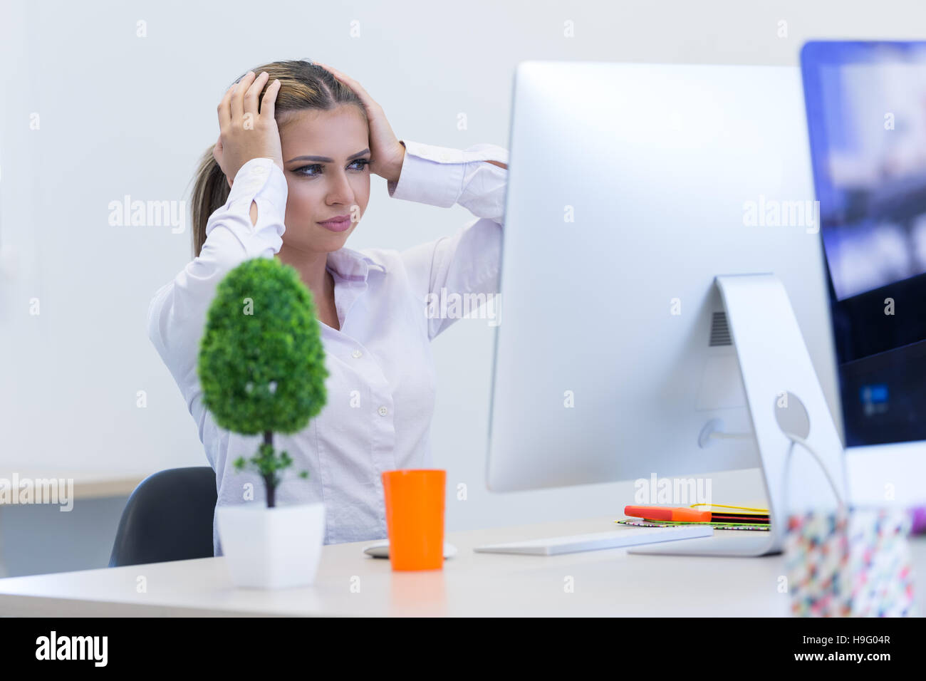 Ritratto di donna seduta imprenditore in ufficio mentre doin Foto Stock