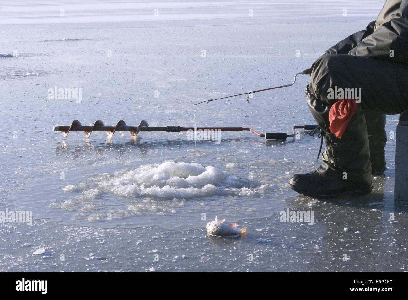 Pesca sul ghiaccio sul lago ghiacciato Foto Stock