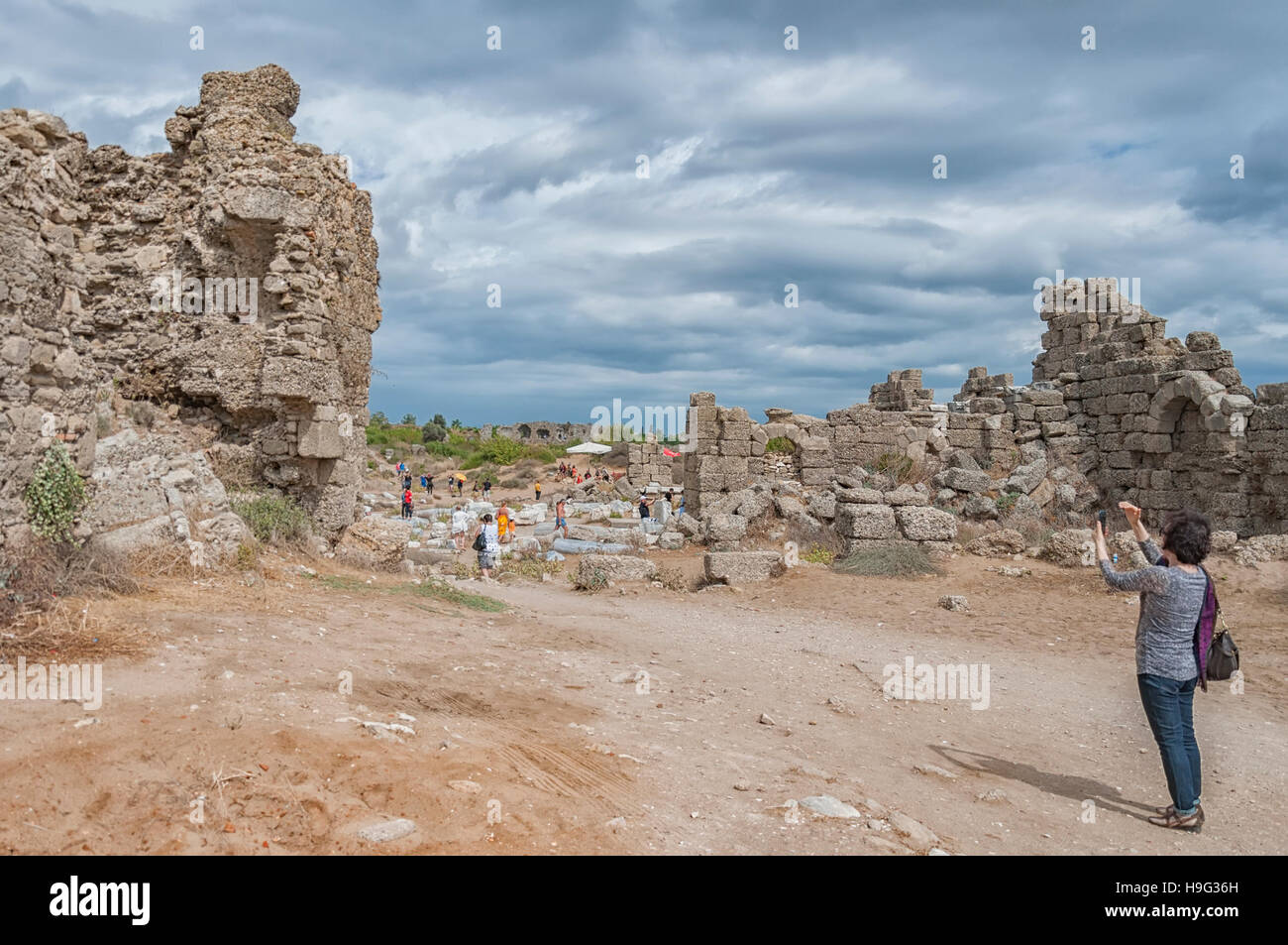 I turisti serpeggianti attraverso le antiche rovine di lato. Foto Stock