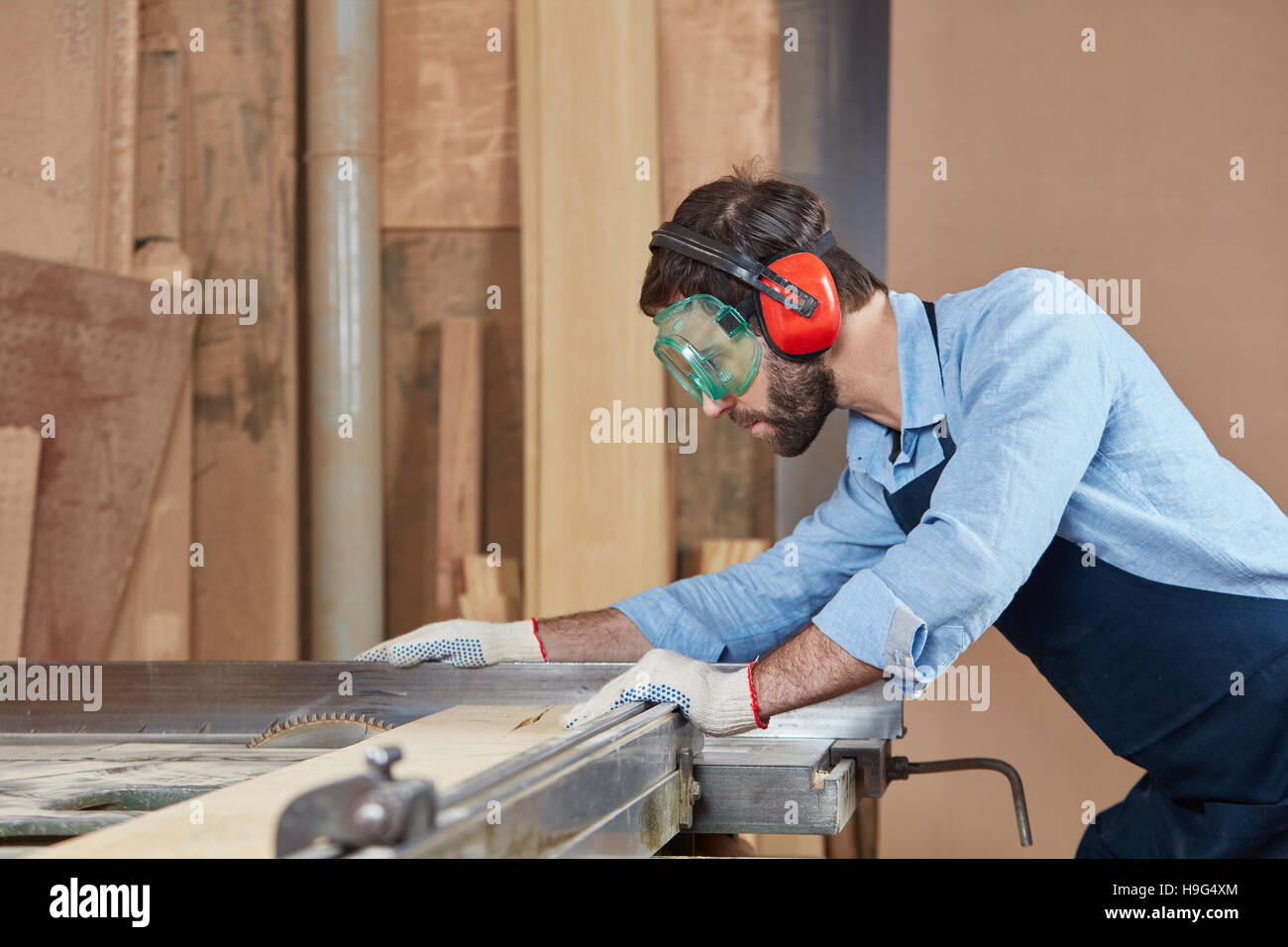 Carpenter il taglio con la sega circolare e la concentrazione Foto Stock