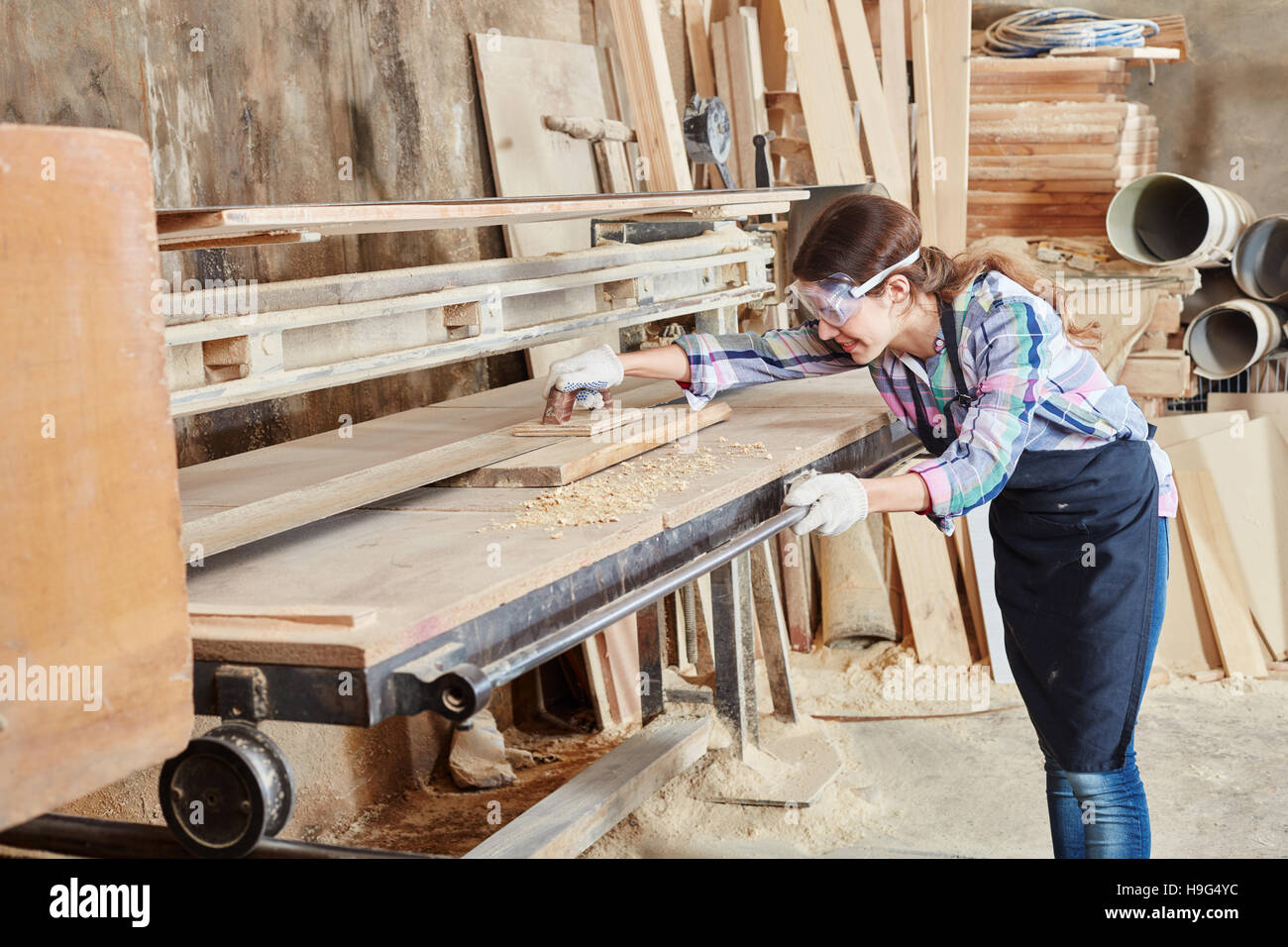 La donna come carpentiere lavora con cinghia macchina di molatura Foto Stock