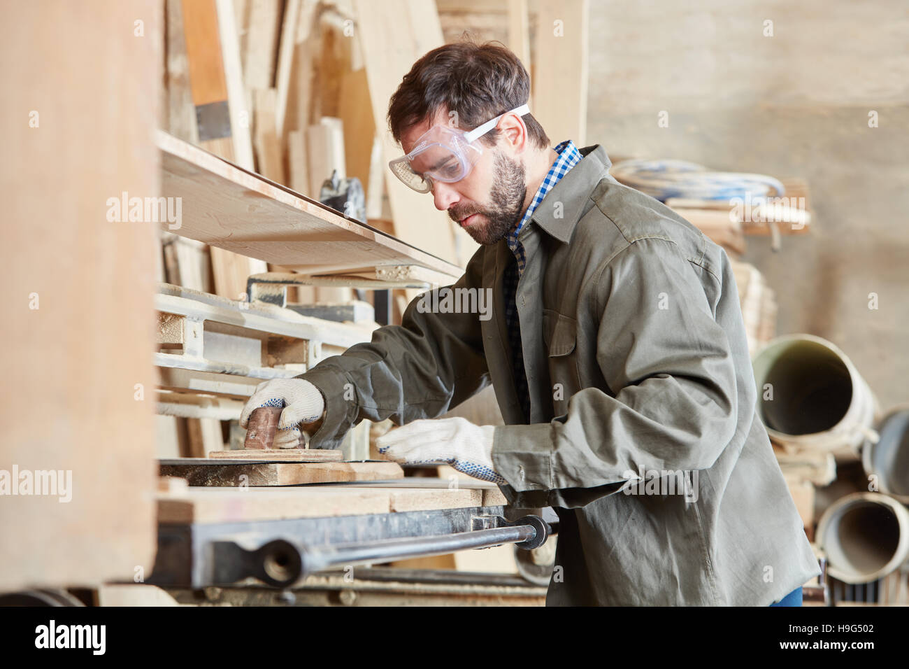 L'uomo come carpentiere macinazione di legno al negozio di falegnameria Foto Stock