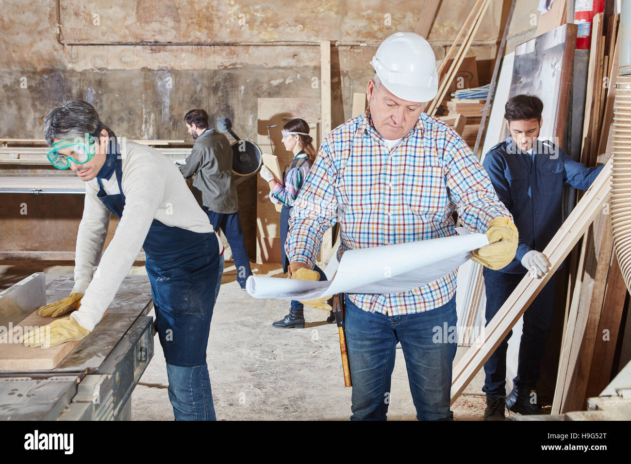 I falegnami di lavorare insieme con master boss senior Foto Stock