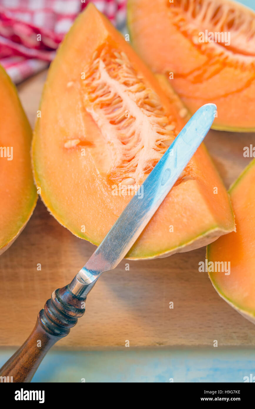 Melone fette di melone e il coltello, il fuoco selettivo Foto Stock