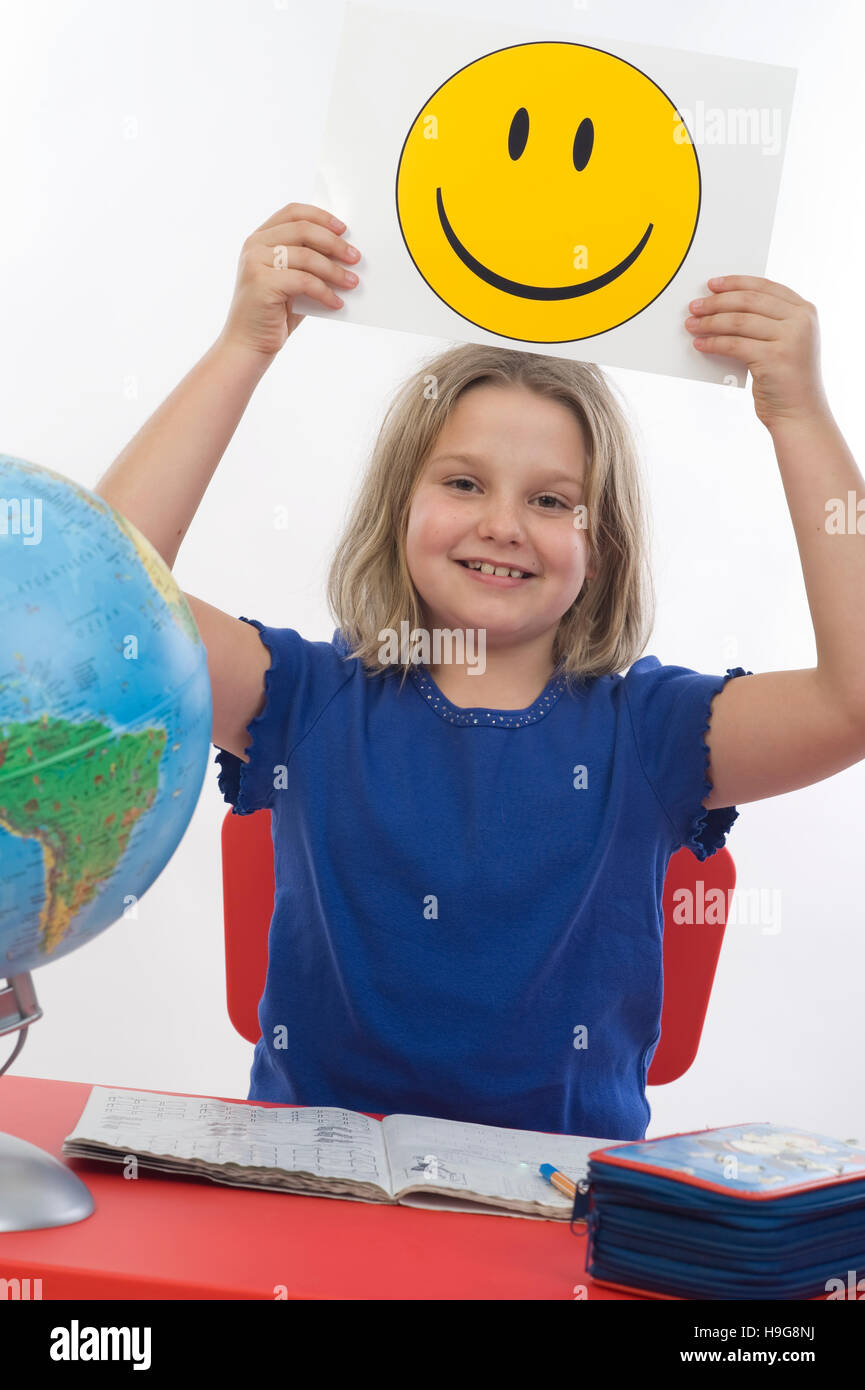 Happy School girl, 8 anni, alla sua scrivania, smiley Foto Stock