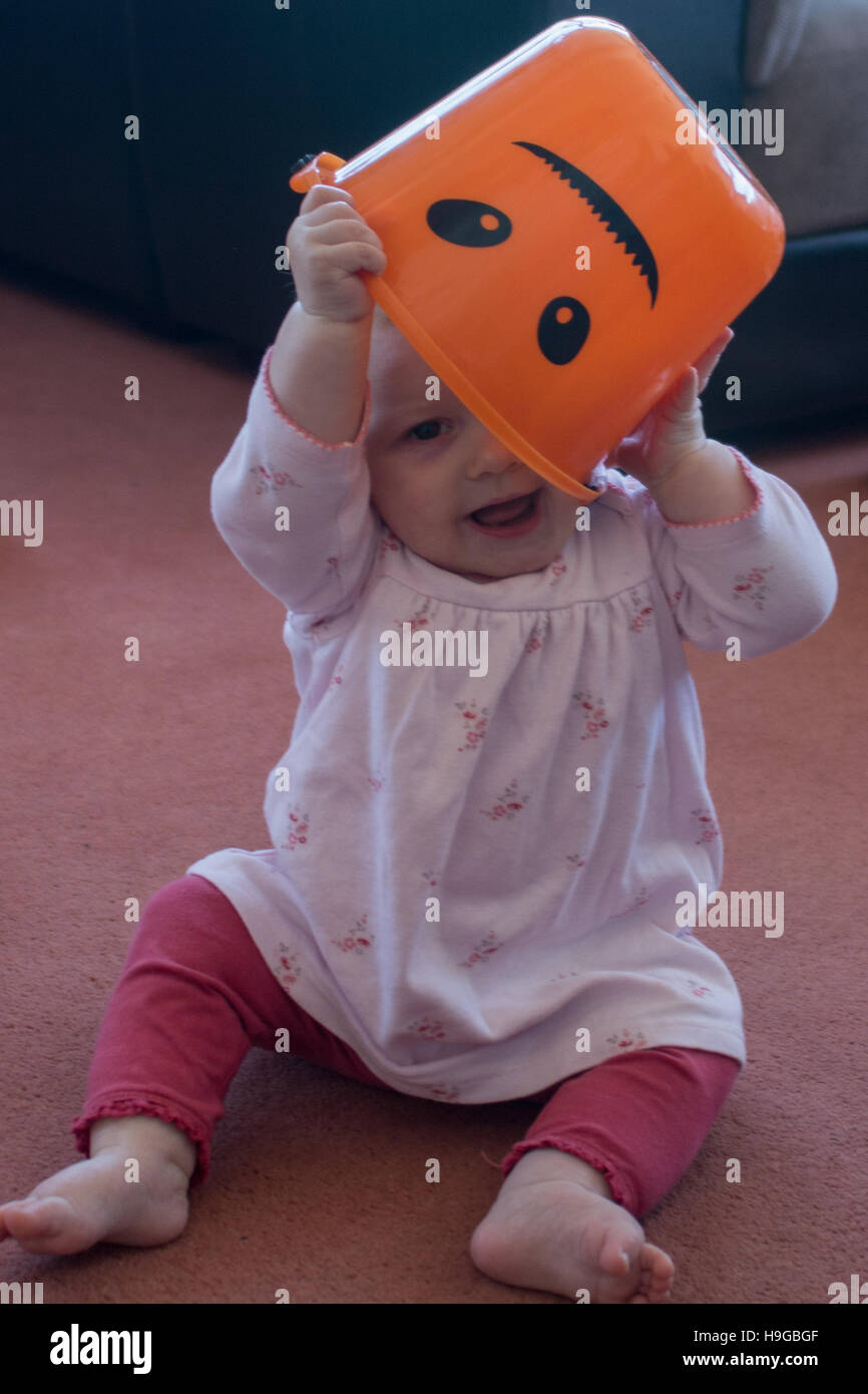 Bambino con Halloween Candy dolce la benna sopra la sua testa, vestito in rosa Foto Stock