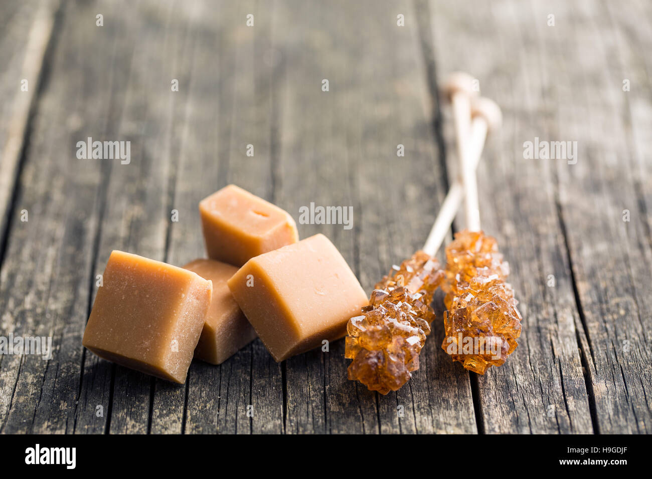 Lo zucchero di canna cristalli sulla memory stick e caramello caramelle sul  vecchio tavolo in legno Foto stock - Alamy