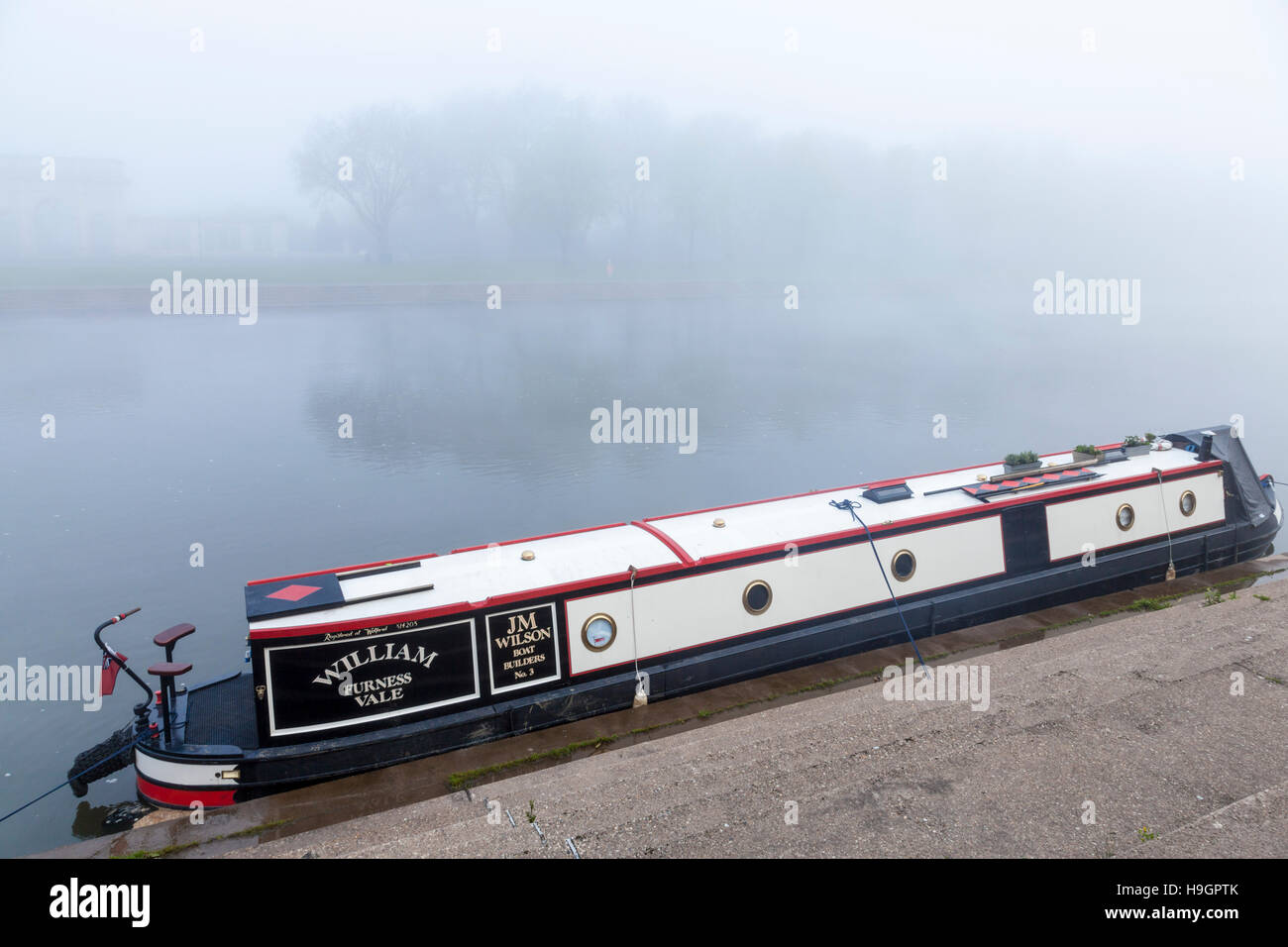 Nebbioso giorno sul fiume. Narrowboat nella nebbia ormeggiato a lato del fiume Trent, West Bridgford, Nottingham, Inghilterra, Regno Unito Foto Stock