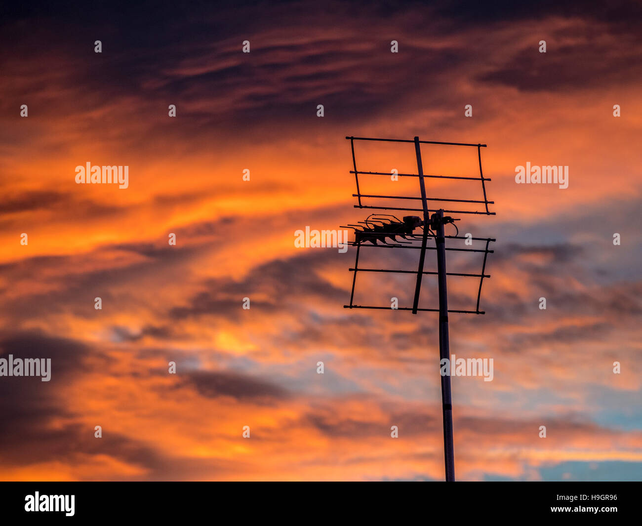 Silhouette dell'antenna TV contro il drammatico tramonto Foto Stock