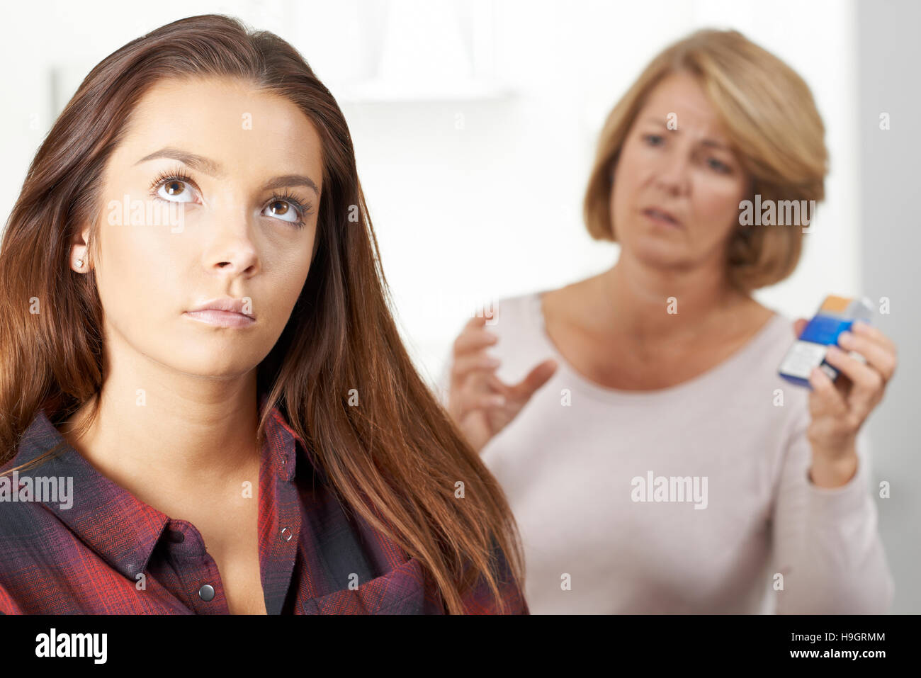 Madre di parlare alla figlia adolescente circa i pericoli del fumo Foto Stock