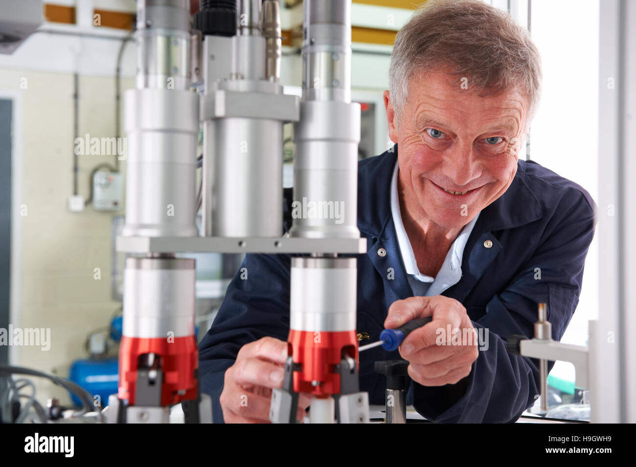 Ritratto di ingegnere maschio lavorando sulla macchina in fabbrica Foto Stock