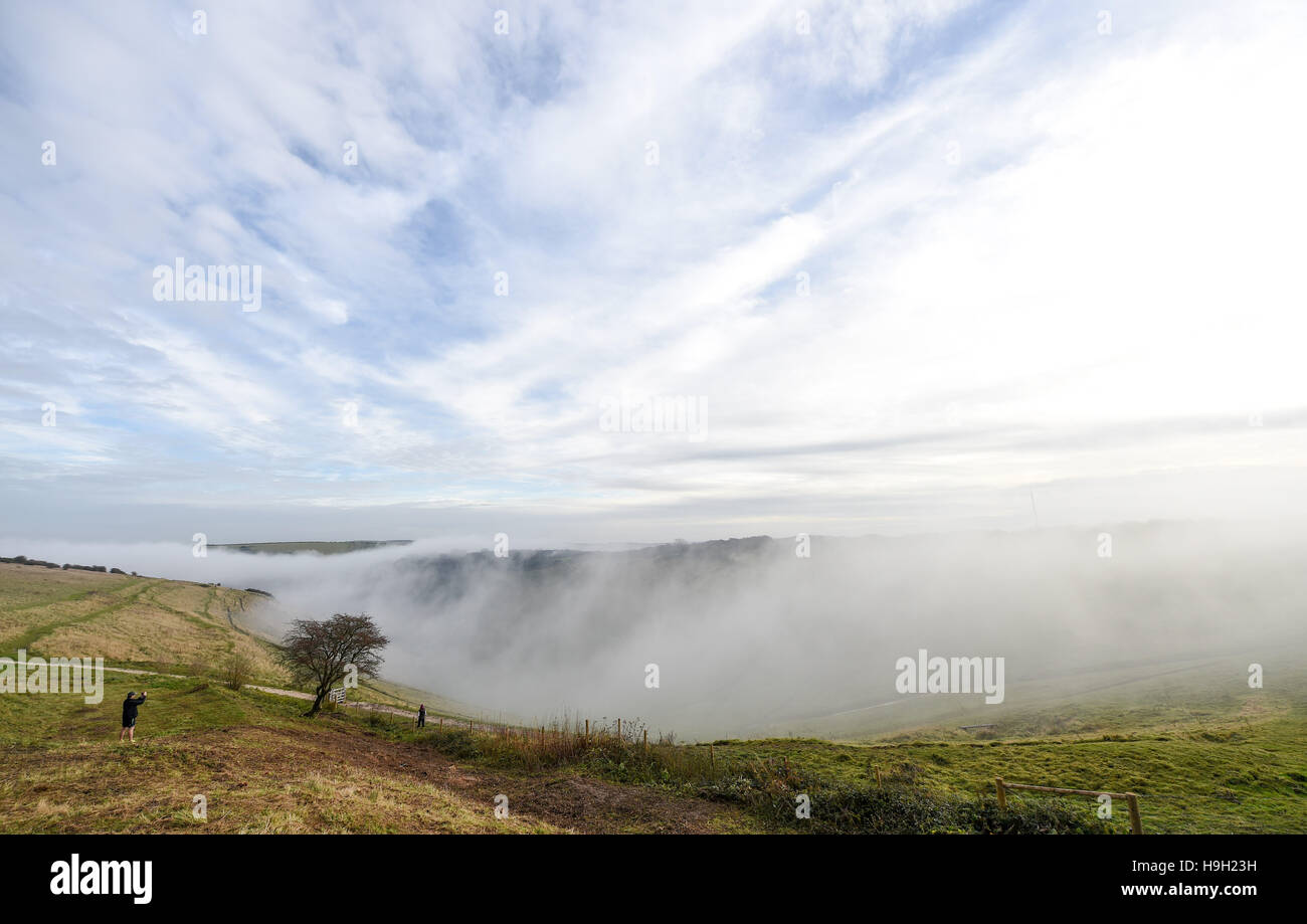 Brighton, Sussex, Regno Unito. 23 Nov, 2016. La mattina presto walkers godetevi la foschia e la nebbia a cascata verso il basso sulle colline ai demoni Dyke lungo il South Downs a nord di Brighton dopo gli ultimi giorni di maltempo in tutto il Regno Unito Credito: Simon Dack/Alamy Live News Foto Stock