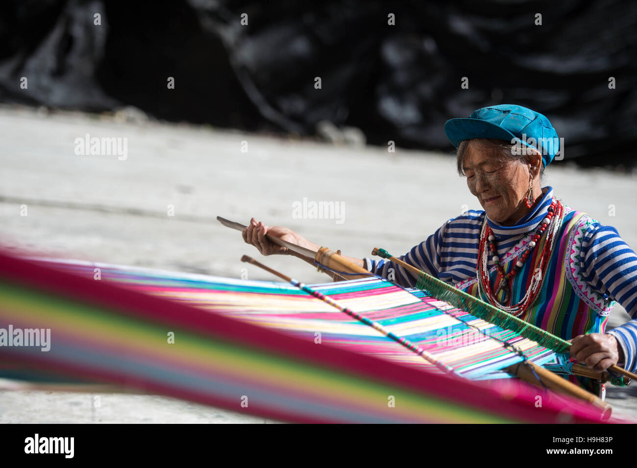 (161124) -- DULONGJIANG, nov. 24, 2016 (Xinhua) -- Il 73-anno-vecchio Li Wenshi tesse un tappeto in Dizhengdang villaggio di Dulongjiang Township, a sud-ovest della Cina di Provincia di Yunnan, nov. 23, 2016. Dulongjiang Township è casa per persone di Dulong gruppo etnico. A causa di abominevoli condizioni naturali, l'economia locale è stato sviluppato in passato. Dopo anni di sviluppo, le strade sono state lastricate e moderne case di abitazione costruita per sostituire la sterpaglia-case coperte. Il rurale assicurazione medica ha coperto il 98 percento degli abitanti del villaggio e tutti i bambini in età scolare hanno ricevuto l'educazione a scuola. L'orecchio medio Foto Stock