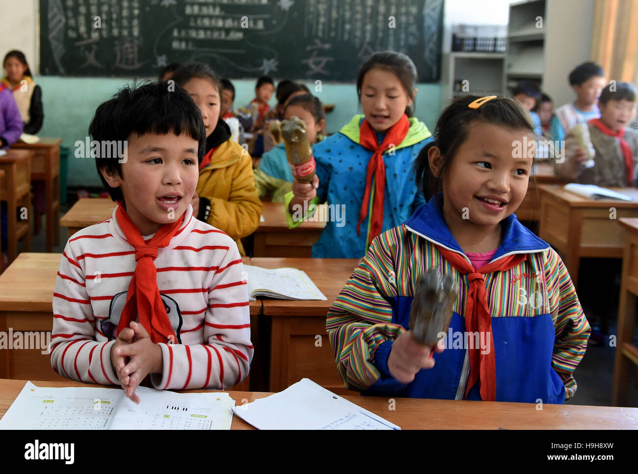 (161124) -- DULONGJIANG, nov. 24, 2016 (Xinhua) -- Gli studenti frequentano le lezioni di musica in una scuola primaria in Dulongjiang Township, a sud-ovest della Cina di Provincia di Yunnan, nov. 23, 2016. Dulongjiang Township è casa per persone di Dulong gruppo etnico. A causa di abominevoli condizioni naturali, l'economia locale è stato sviluppato in passato. Dopo anni di sviluppo, le strade sono state lastricate e moderne case di abitazione costruita per sostituire la sterpaglia-case coperte. Il rurale assicurazione medica ha coperto il 98 percento degli abitanti del villaggio e tutti i bambini in età scolare hanno ricevuto l'educazione a scuola. Il reddito medio per ogni y Foto Stock