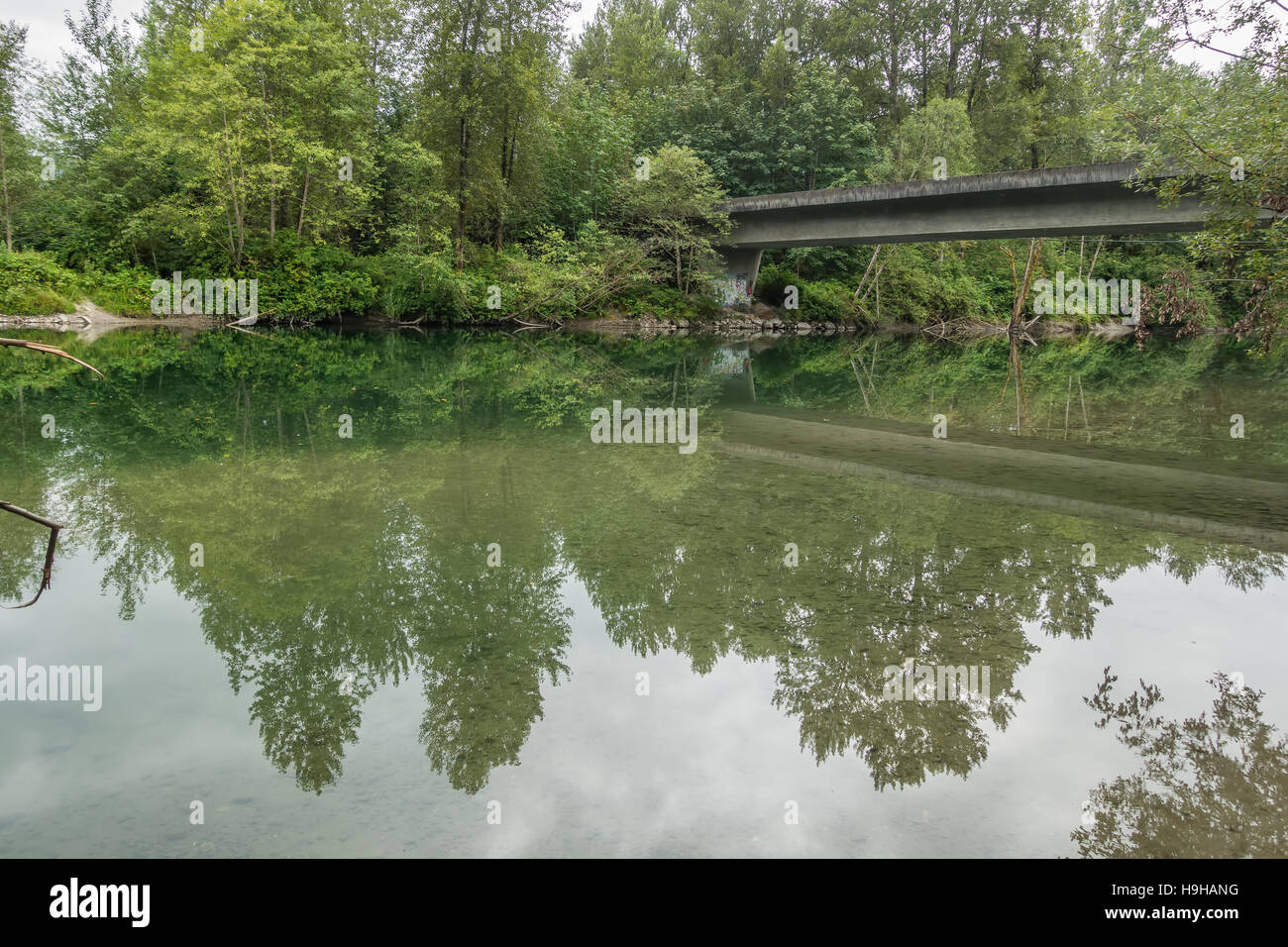 Un ponte e gli alberi sono riflesse in un fiume in North Bend, Washington. Foto Stock