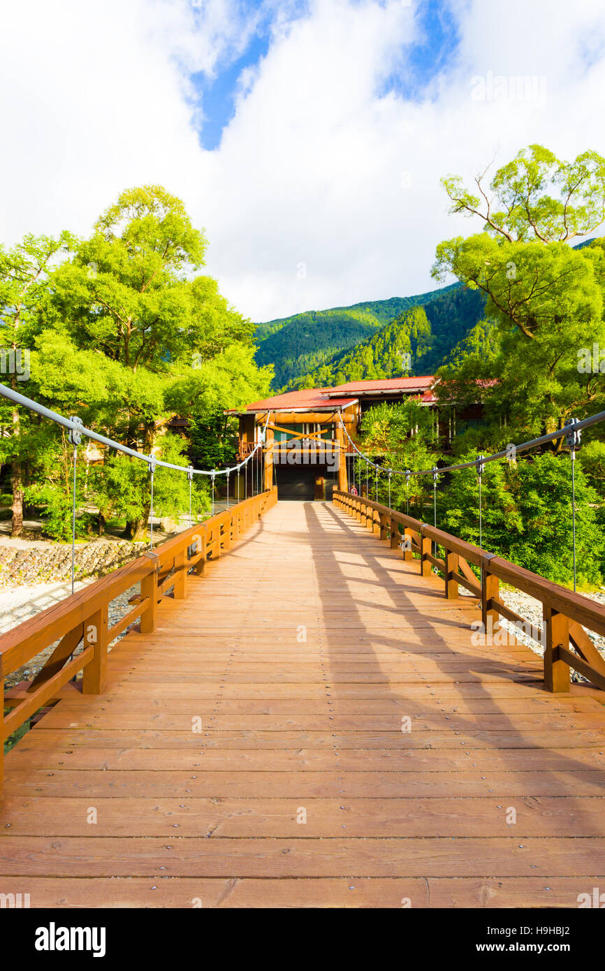 Centrato ponte di legno del Kappa-Bashi ponte che conduce al hotel appartato in mattina presto luce nelle Alpi giapponesi città di Ka Foto Stock