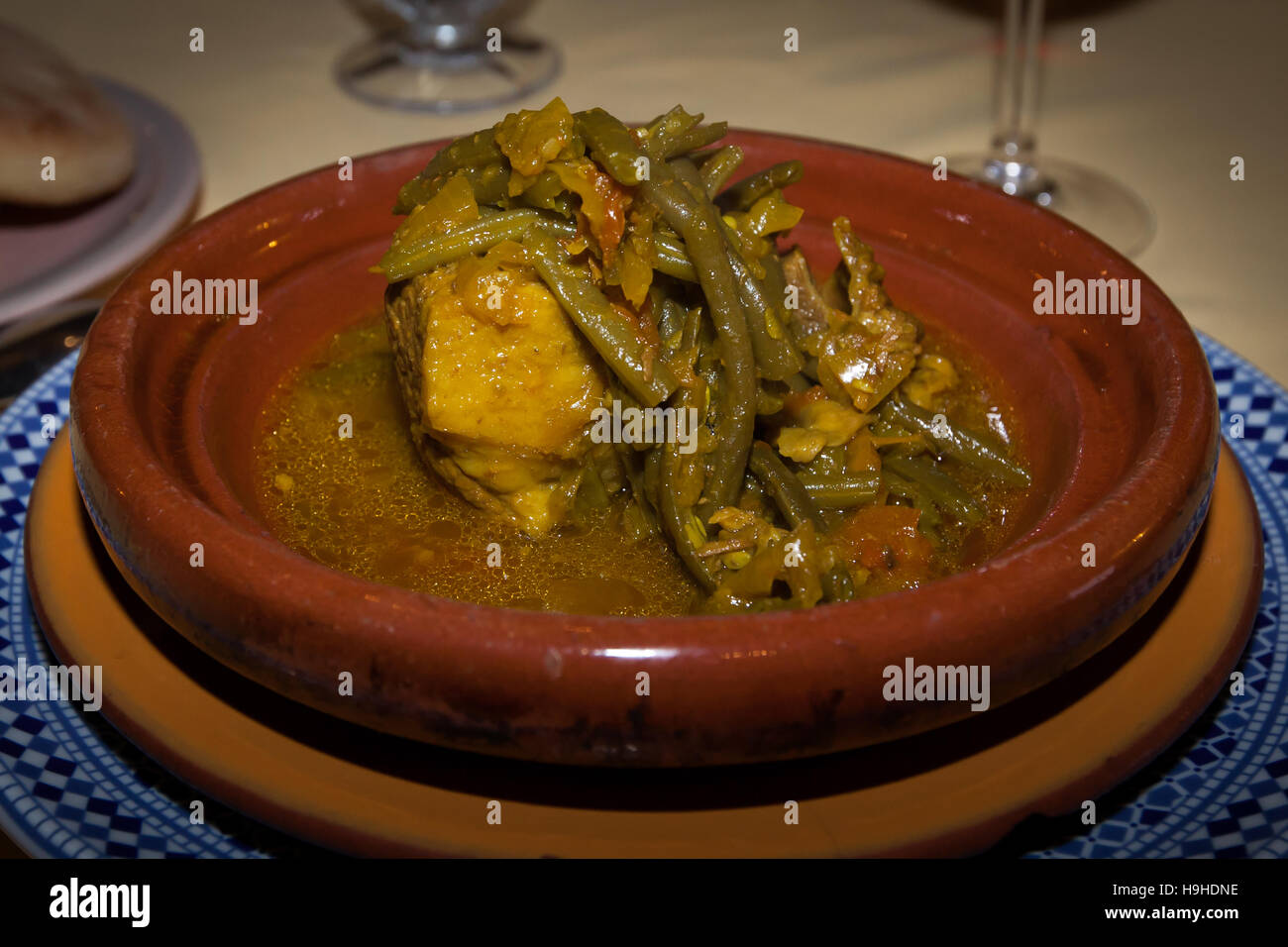 Un tagine di fagiolini e carne che fumano in una salsa speziata in una pentola di terracotta in un ristorante a Fès, Marocco, condito con la miscela di spezie marocchina Ras el Hanout. Foto Stock