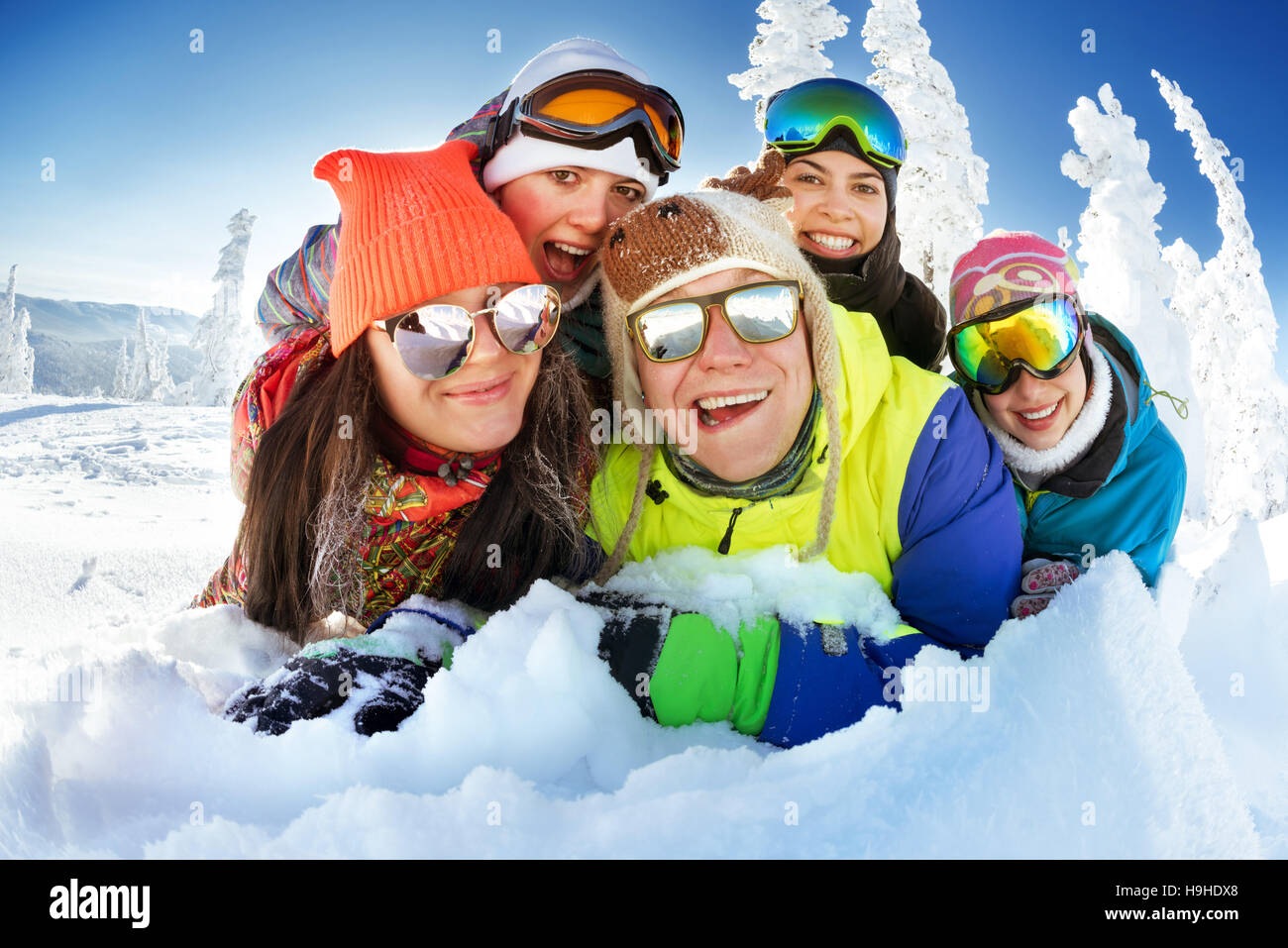 Gruppo di amici felice snowbarders e sciatori Foto Stock