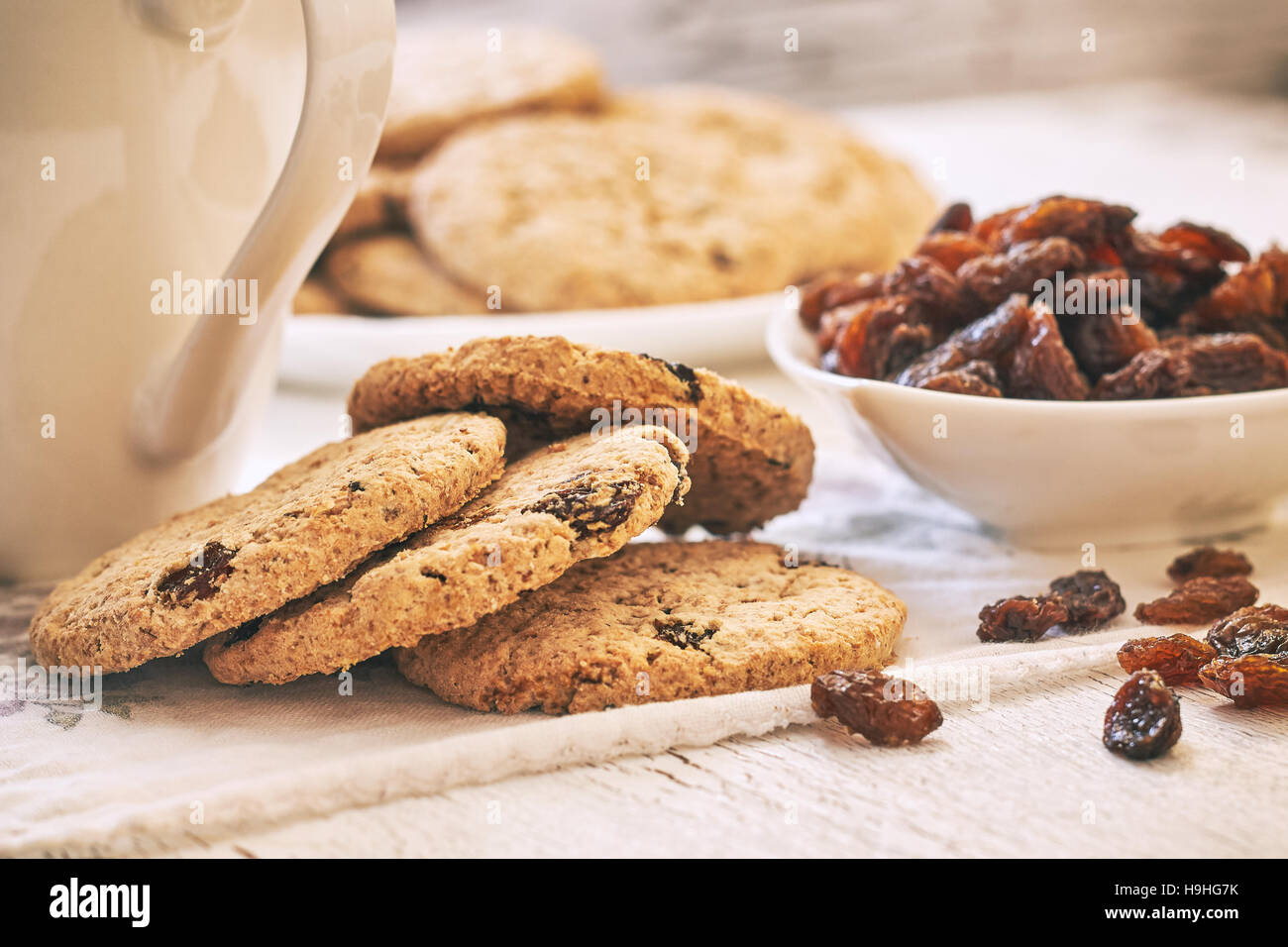 Frumento integrale biscotti con uvetta su bianco tavolo rustico Foto Stock