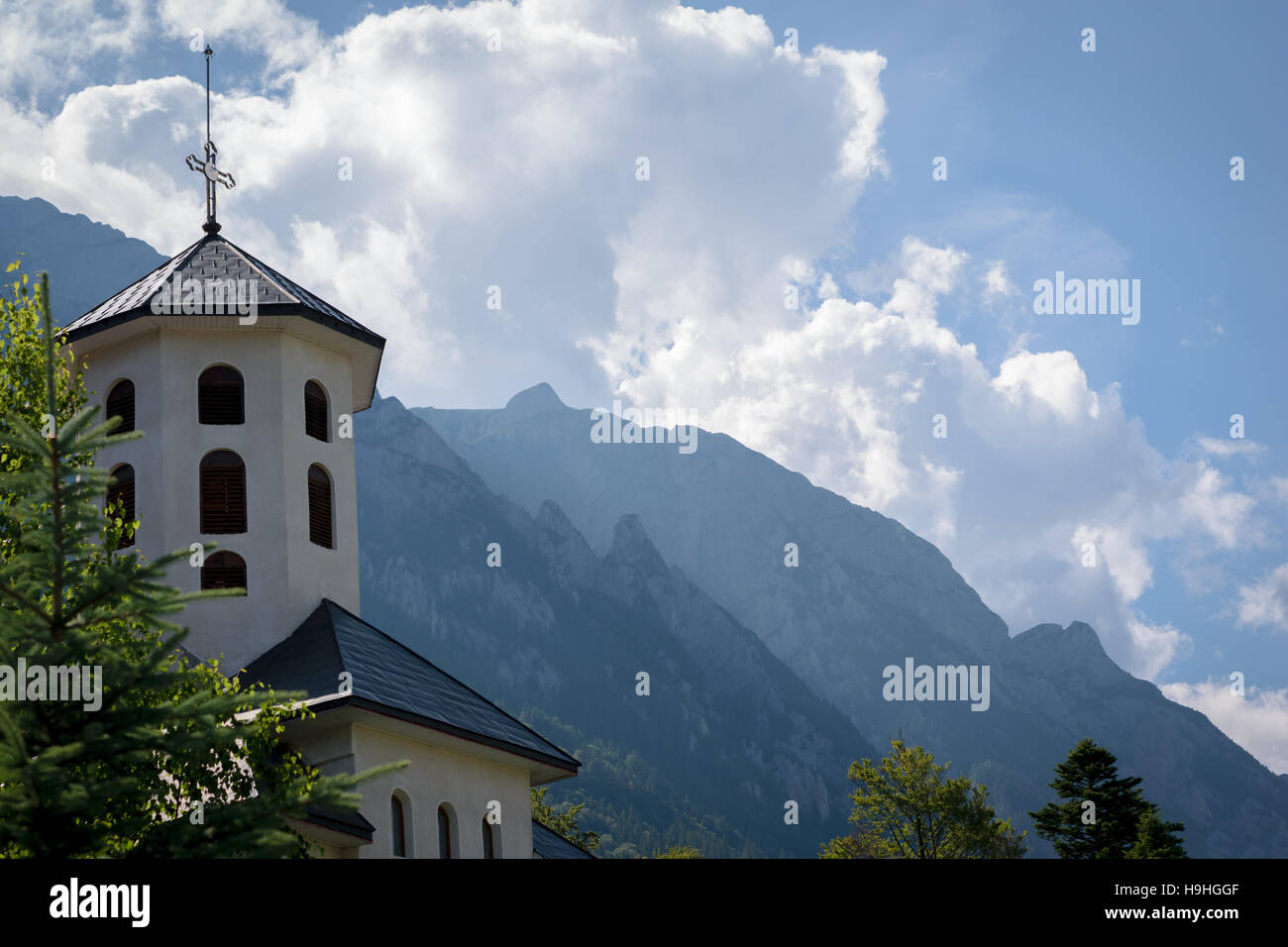 Il campanile della chiesa con le montagne sullo sfondo Foto Stock