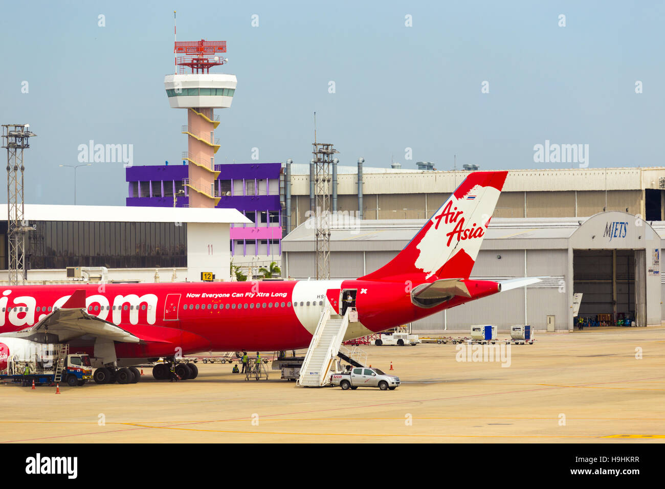 Scale auto parcheggiate presso la sezione di coda della Red Air Asia aereo nella parte anteriore della torre di controllo a Don Mueang airport. Posizione orizzontale Foto Stock