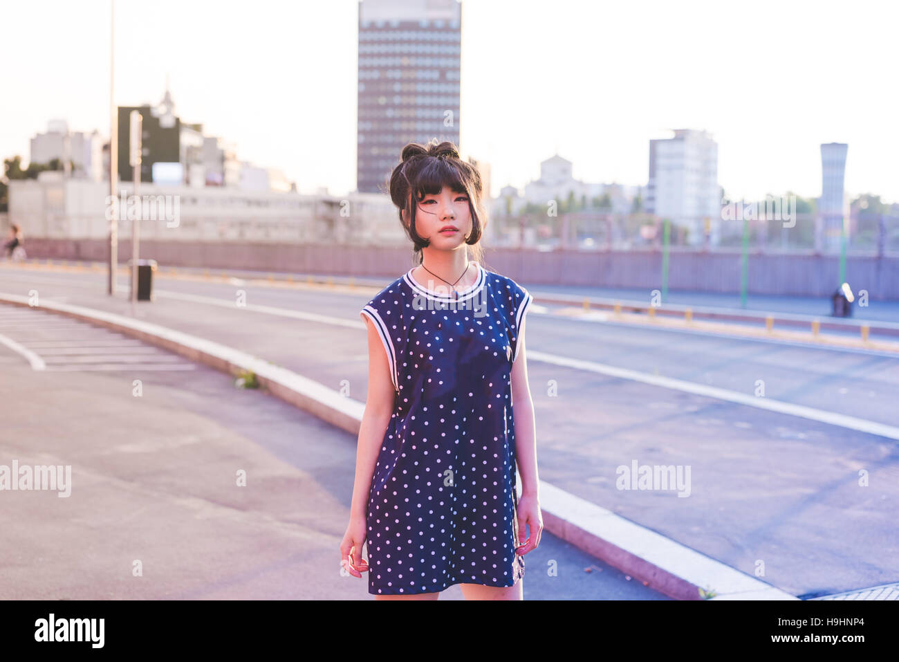 Giovane bella anticonformista donna asiatica in posa all'aperto in città, Foto Stock