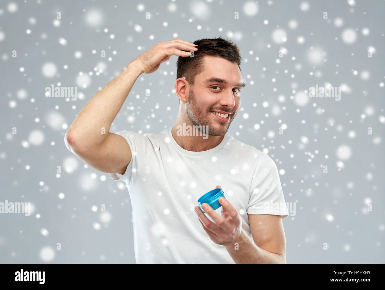 Felice giovane uomo styling i capelli con la cera o gel Foto Stock