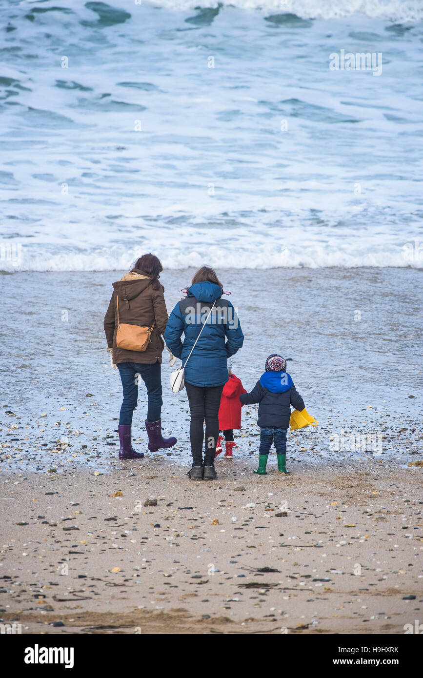 Le mamme e i loro bambini a piedi su Fistral Beach in Newquay, Cornwall. Foto Stock