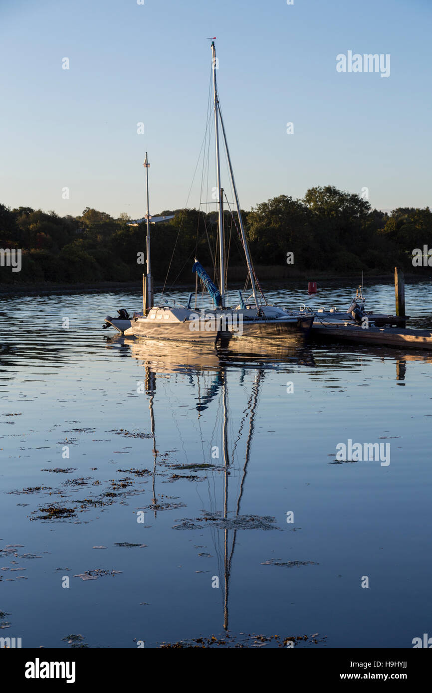 La riflessione in acqua della barca ad ormeggio, Medina Valle Centro Vela, Isle of Wight, Regno Unito Foto Stock