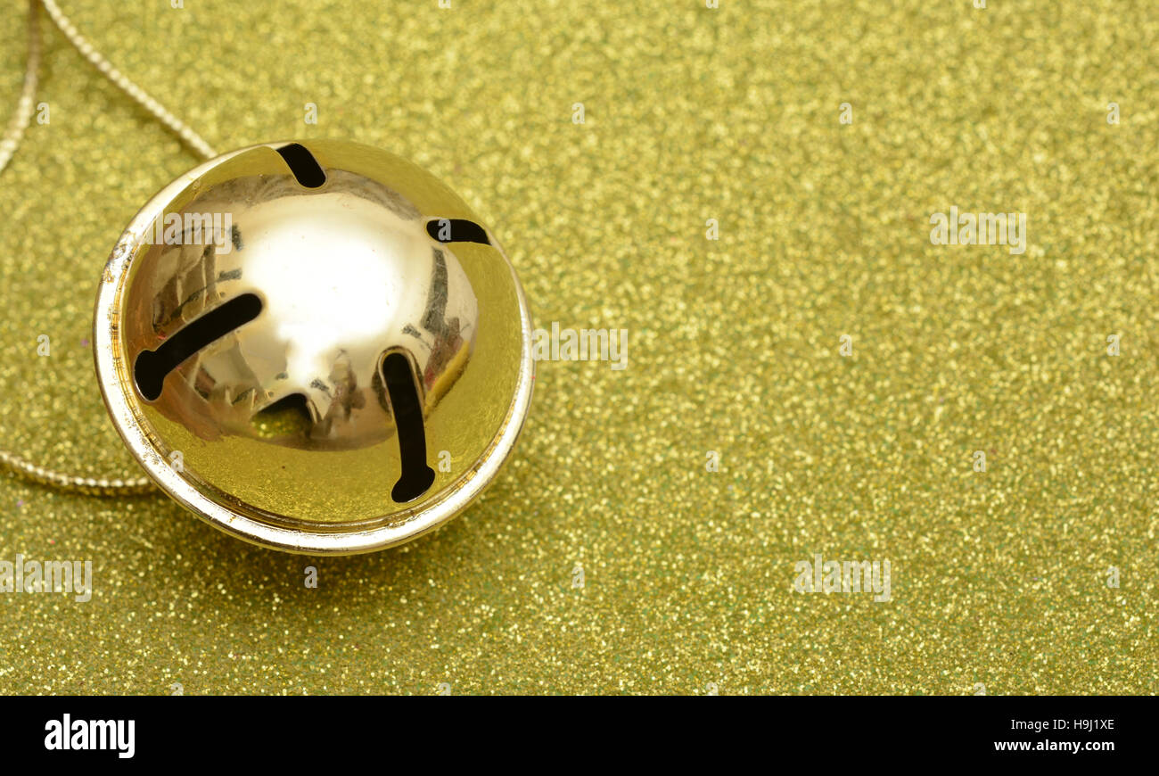 Jingle Bell tema natale vicino sul glitter sfondo. Foto Stock
