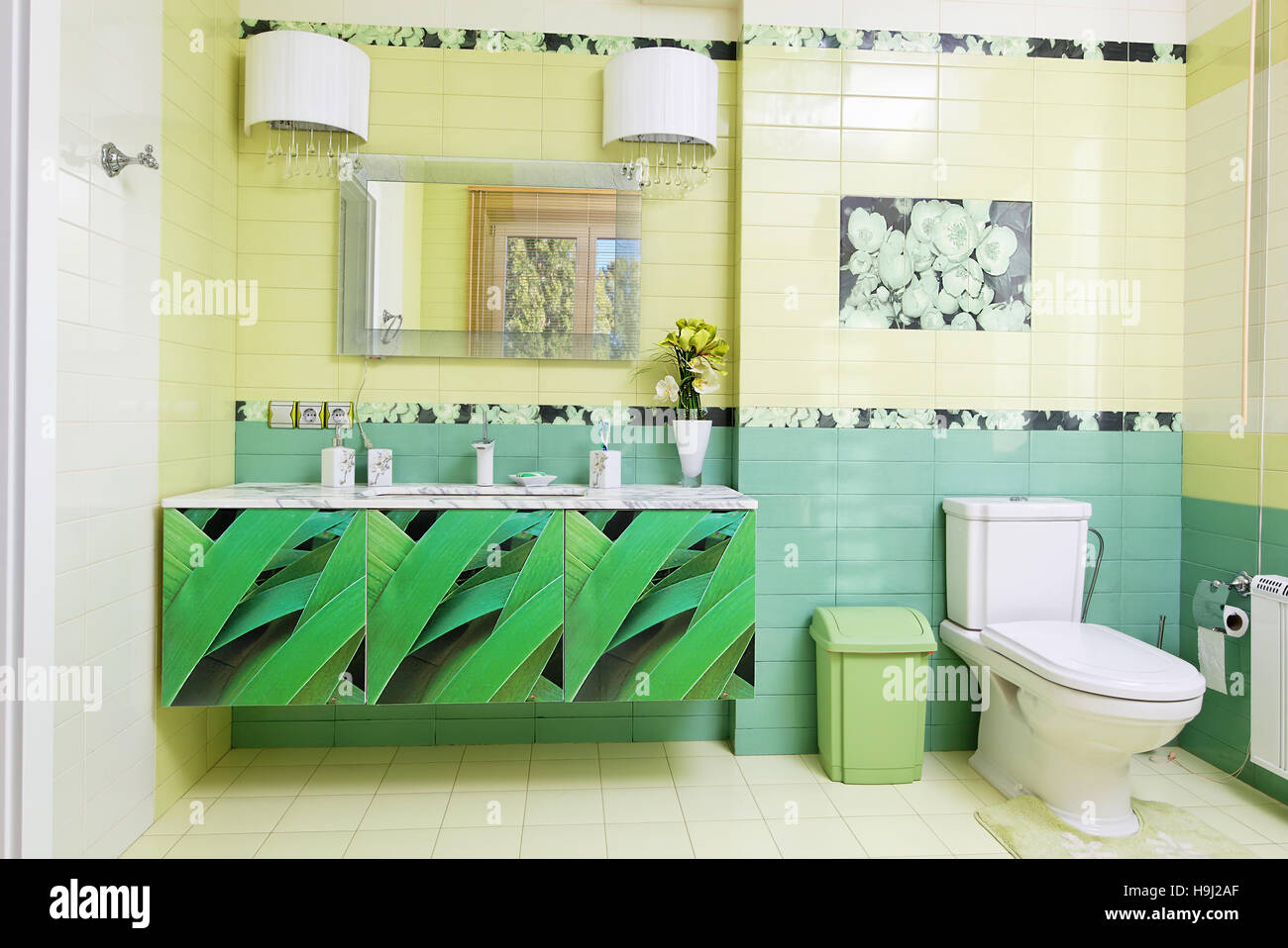 Un bagno dal design moderno in colori verde con stampa orchidea Foto Stock