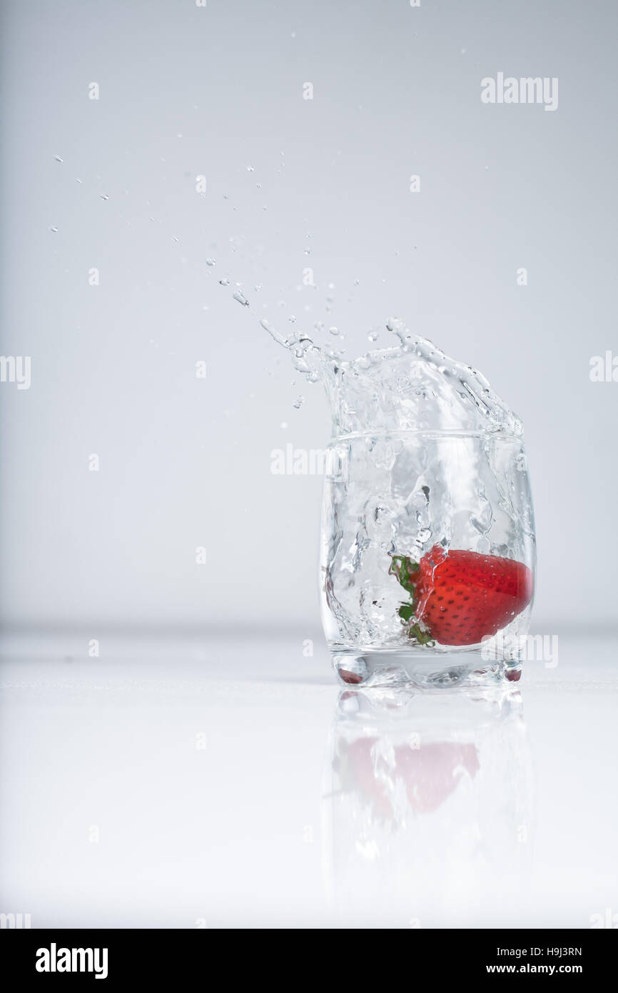 Strawberry splash in acqua glas su sfondo bianco Foto Stock