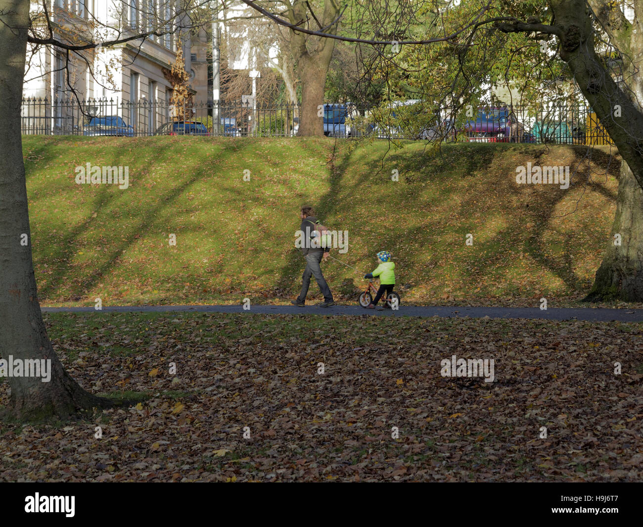 Glasgow park scena padre e figlio guidato da portare in bicicletta Foto Stock