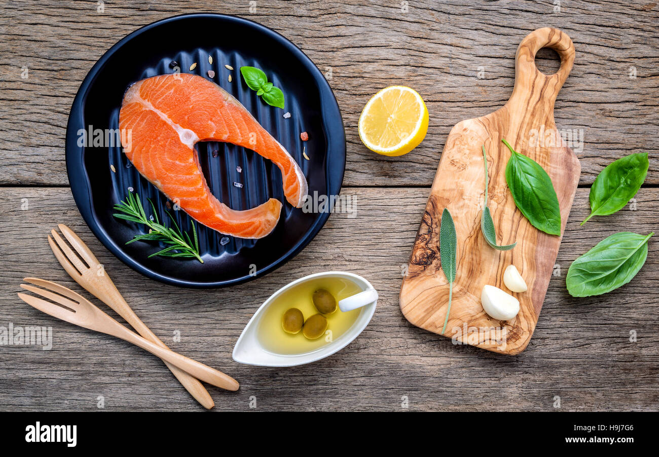 Materie filetto di salmone nella piastra nera con ingredienti olio d'oliva Foto Stock