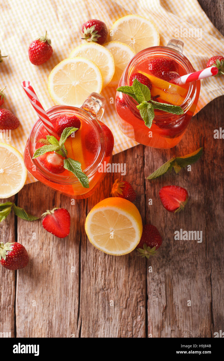 Estate fragola limonata con la menta piperita close-up in un vasetto di vetro sul tavolo. Vista verticale da sopra Foto Stock