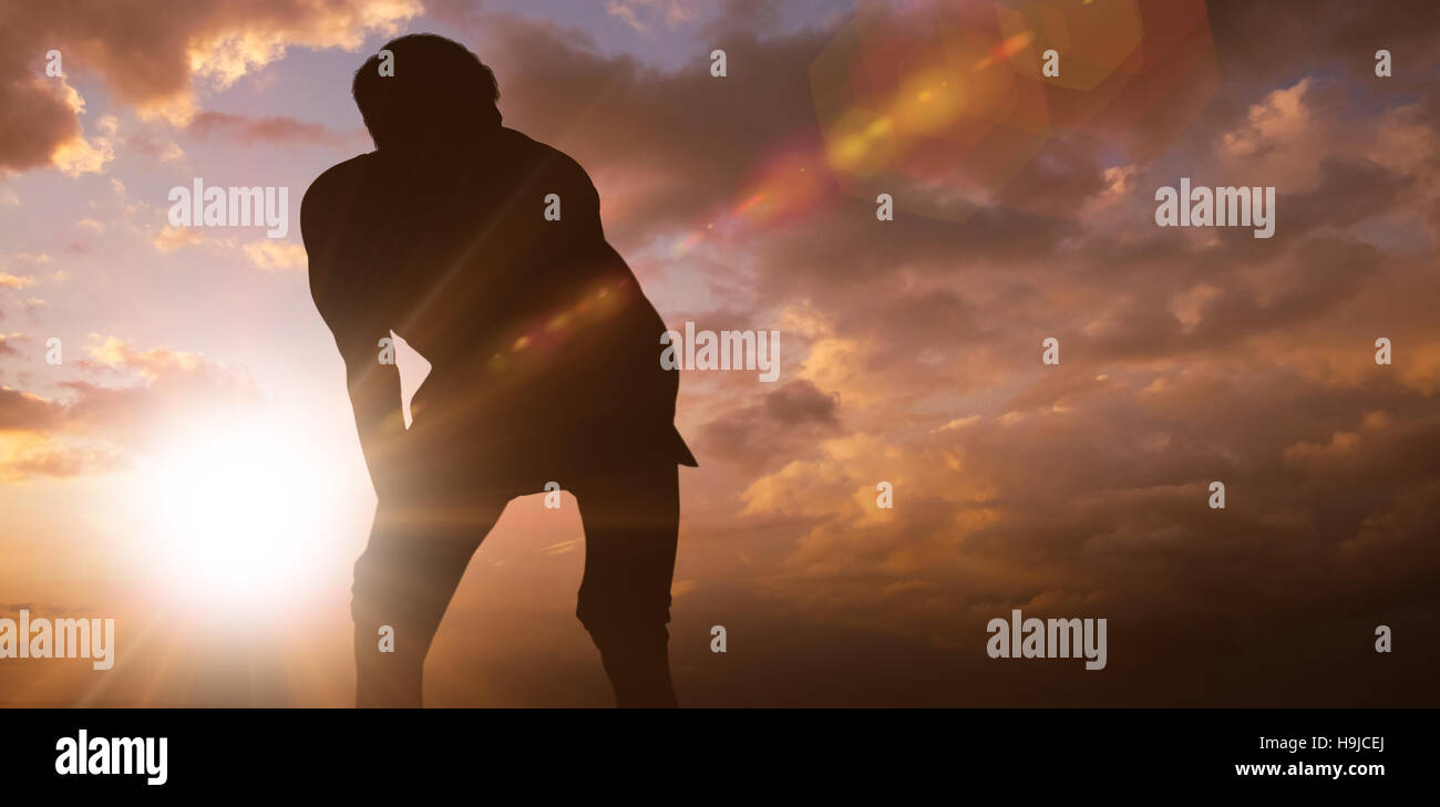 Immagine composita atletico di uomo in appoggio con le mani sulle ginocchia Foto Stock