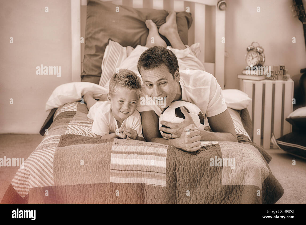 Sorridente little boy e suo padre guardando una partita di calcio Foto Stock