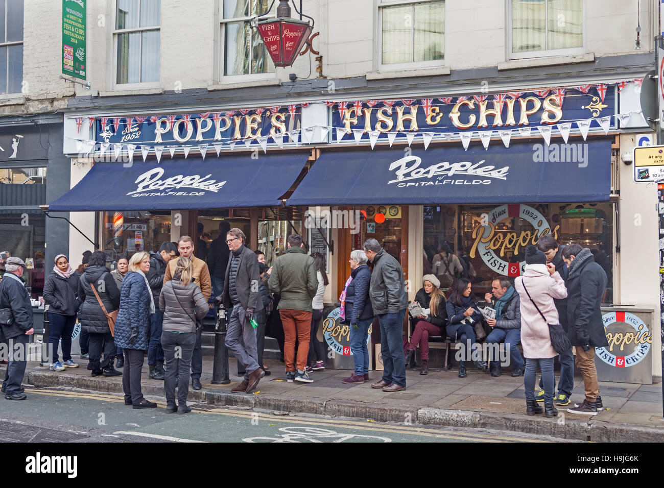 Città di Londra a pranzo folle a papaveri il tradizionale pesce e patatine ristorante in Via Hanbury, Spitalfields Foto Stock
