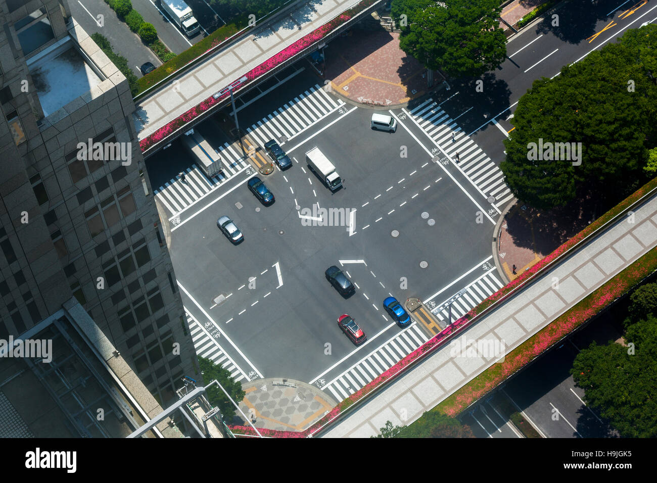 Una intersezione stradale a Tokyo in Giappone dal punto di vista di un grattacielo in vetro. Foto Stock