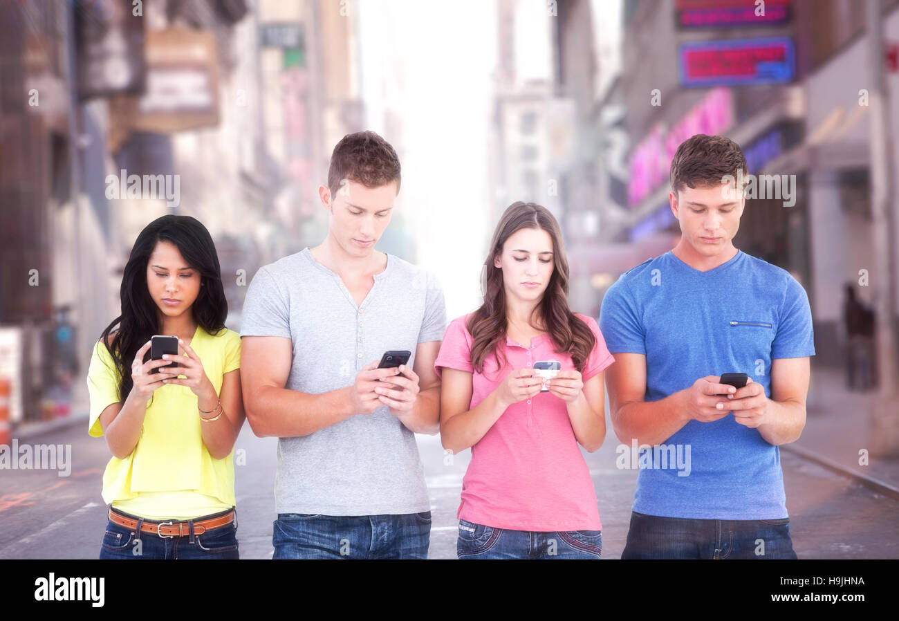 Immagine composita di quattro persone in piedi accanto a ogni altro e scrivere messaggi sui loro telefoni Foto Stock