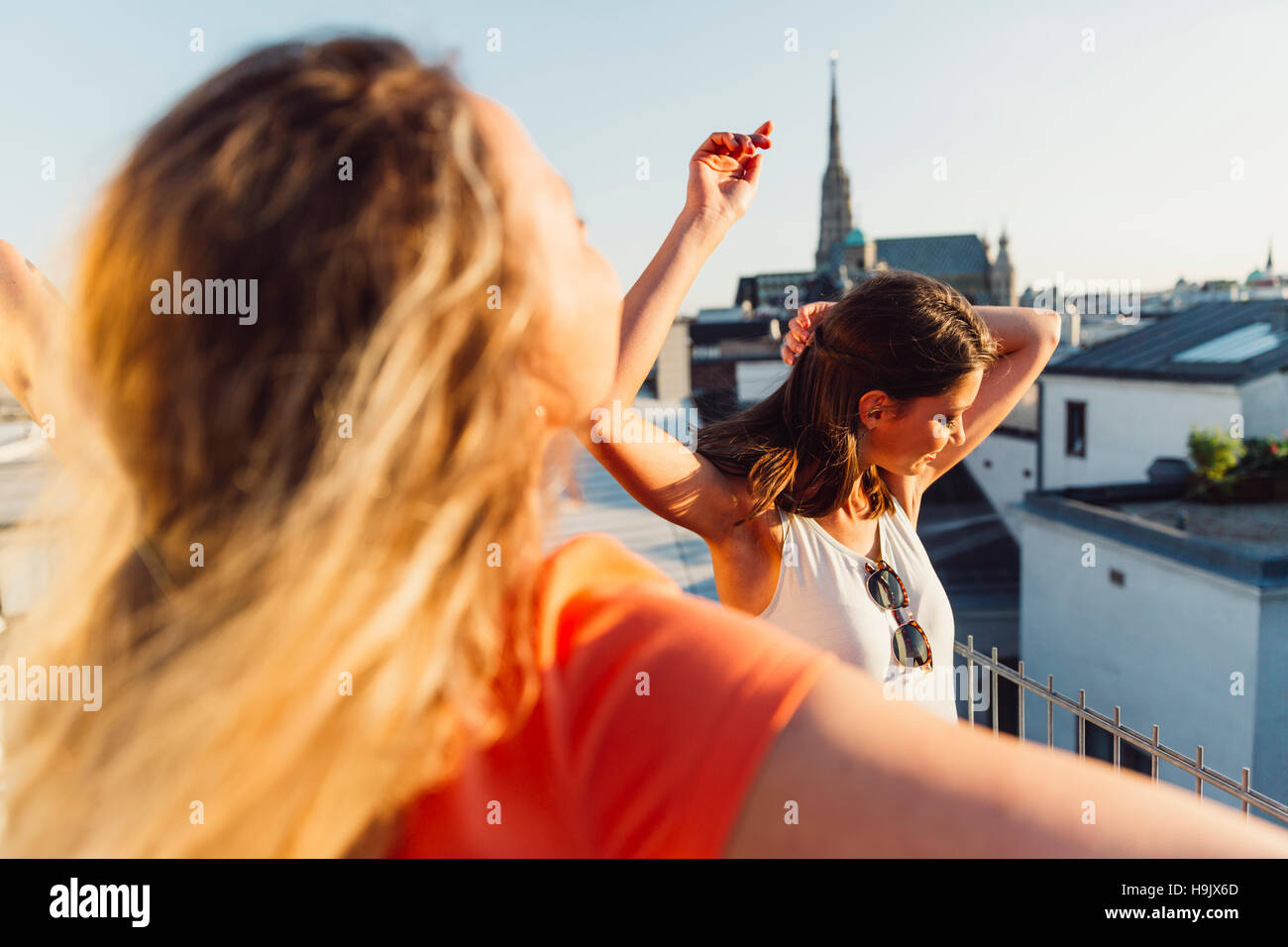 Austria, Vienna, due donne che danzano sulla terrazza sul tetto Foto Stock