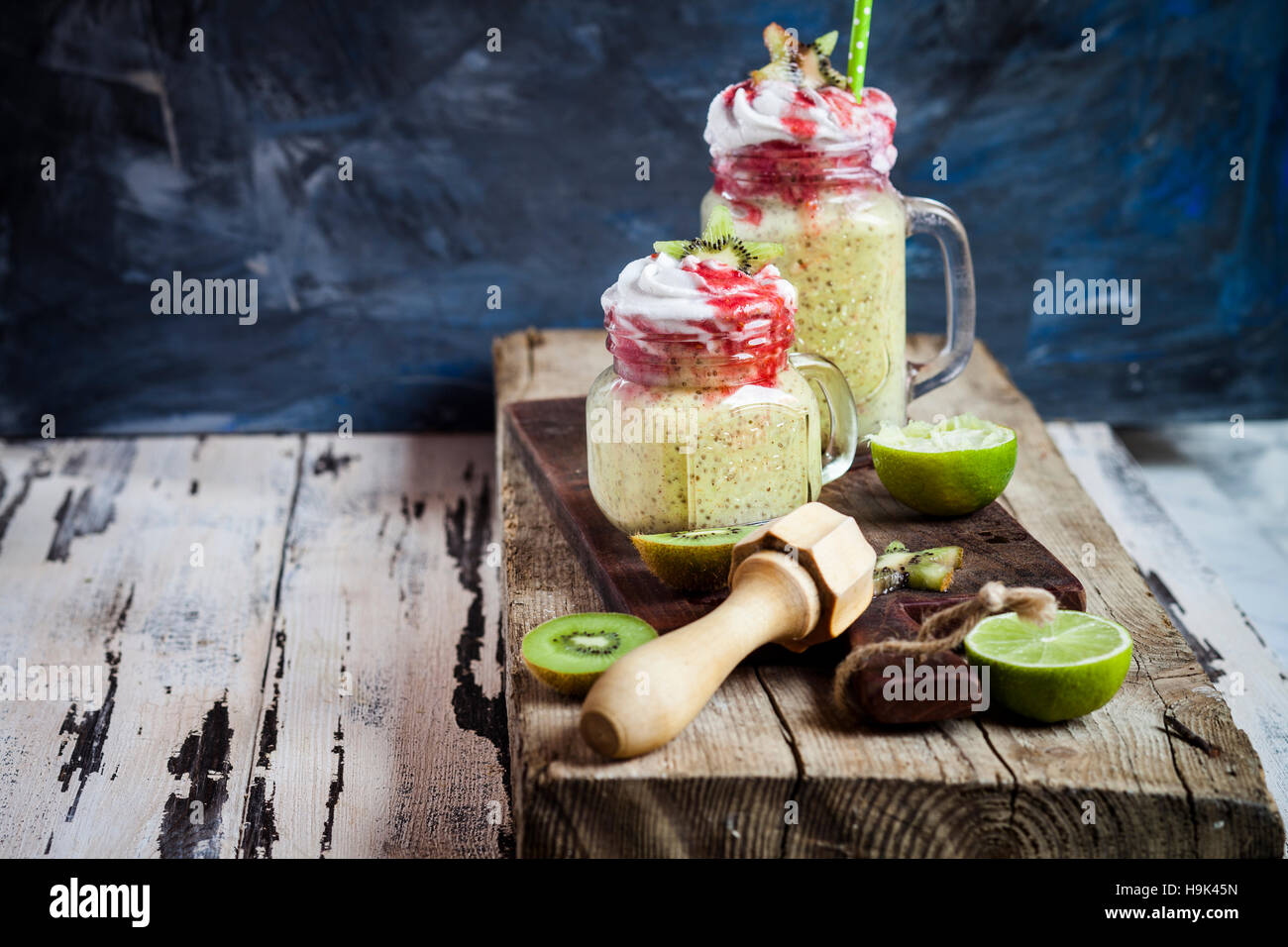 Bicchieri di kiwi limes smoothie con crema di noce di cocco e salsa di lamponi Foto Stock