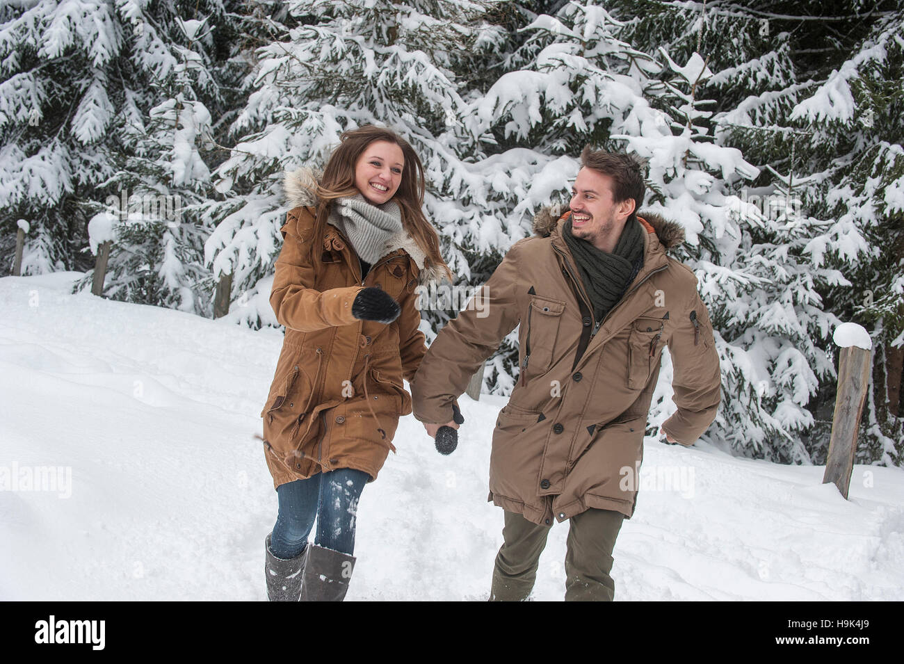 Coppia felice a piedi nella foresta di inverno Foto Stock