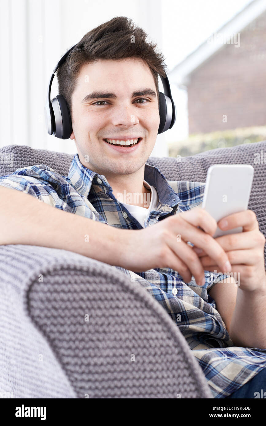 L'uomo streaming di musica dal telefono cellulare alle cuffie senza fili Foto Stock