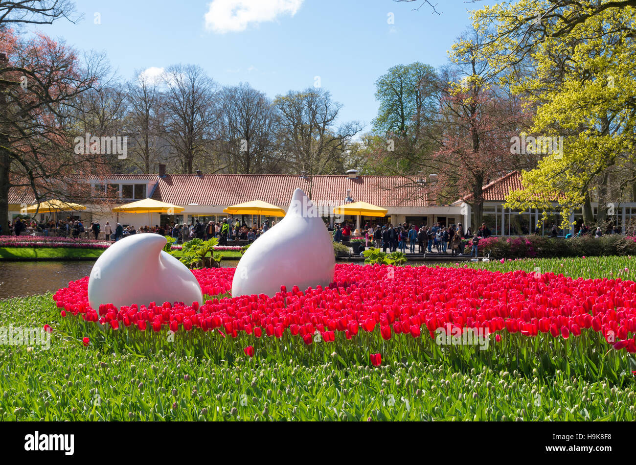 LISSE, Paesi Bassi - 17 Aprile 2016: oggetti di arte in un campo di fioritura di tulipani rossi nei famosi giardini Keukenhof nei Paesi Bassi Foto Stock