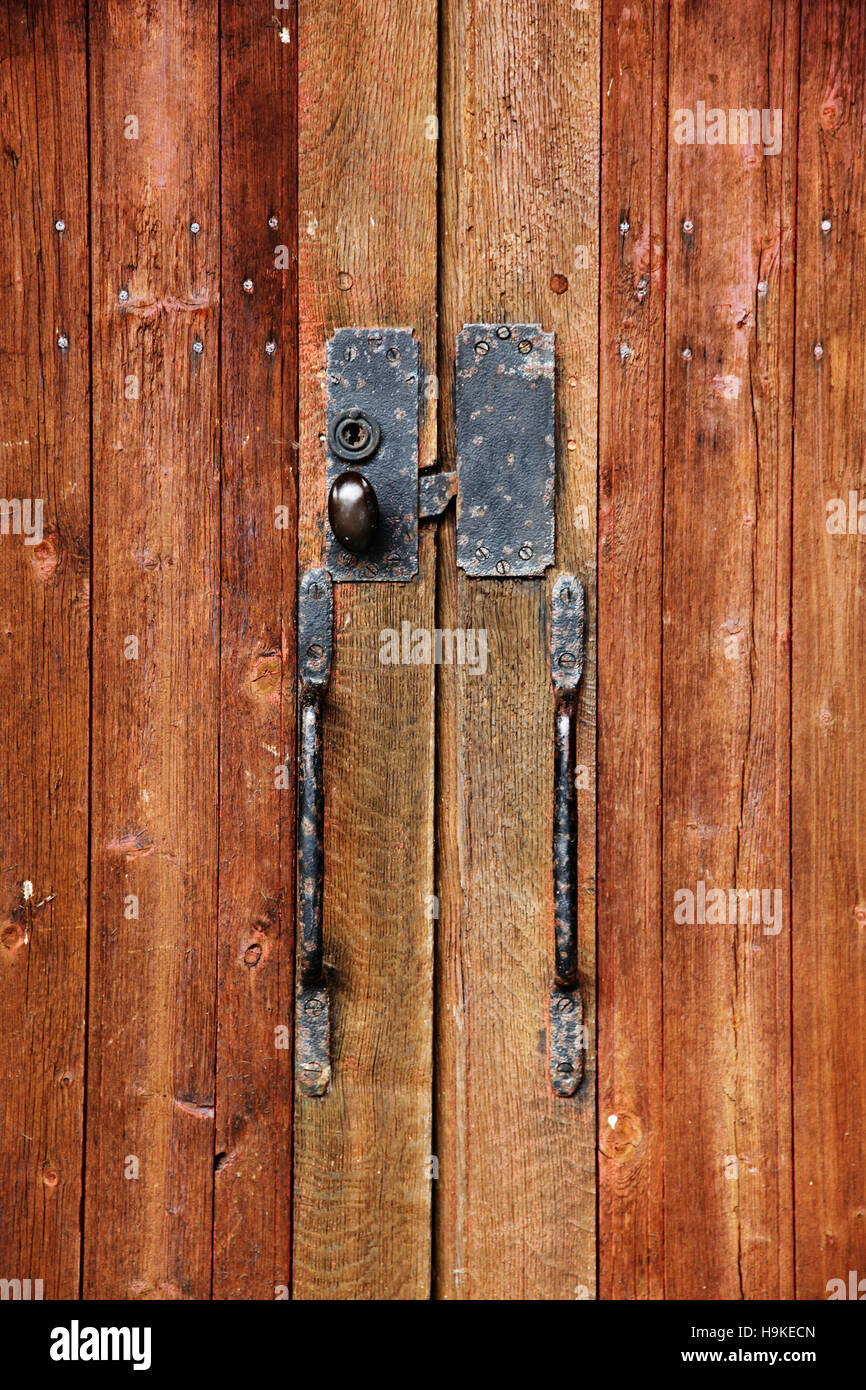 Close-up su una maniglia di porta di una grande porta di legno di una fattoria in Normandia, Francia Foto Stock