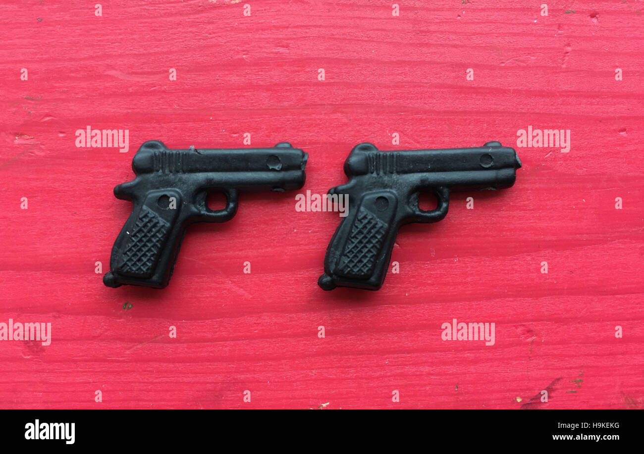 Tiny pistole giocattolo su uno sfondo di legno texture Foto Stock