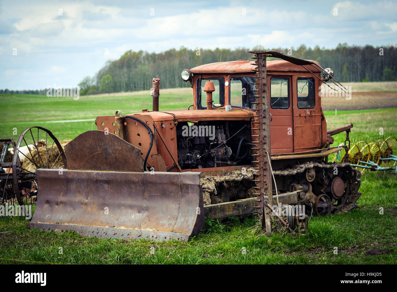 Vecchio arrugginito trattore cingolato con pala Foto Stock