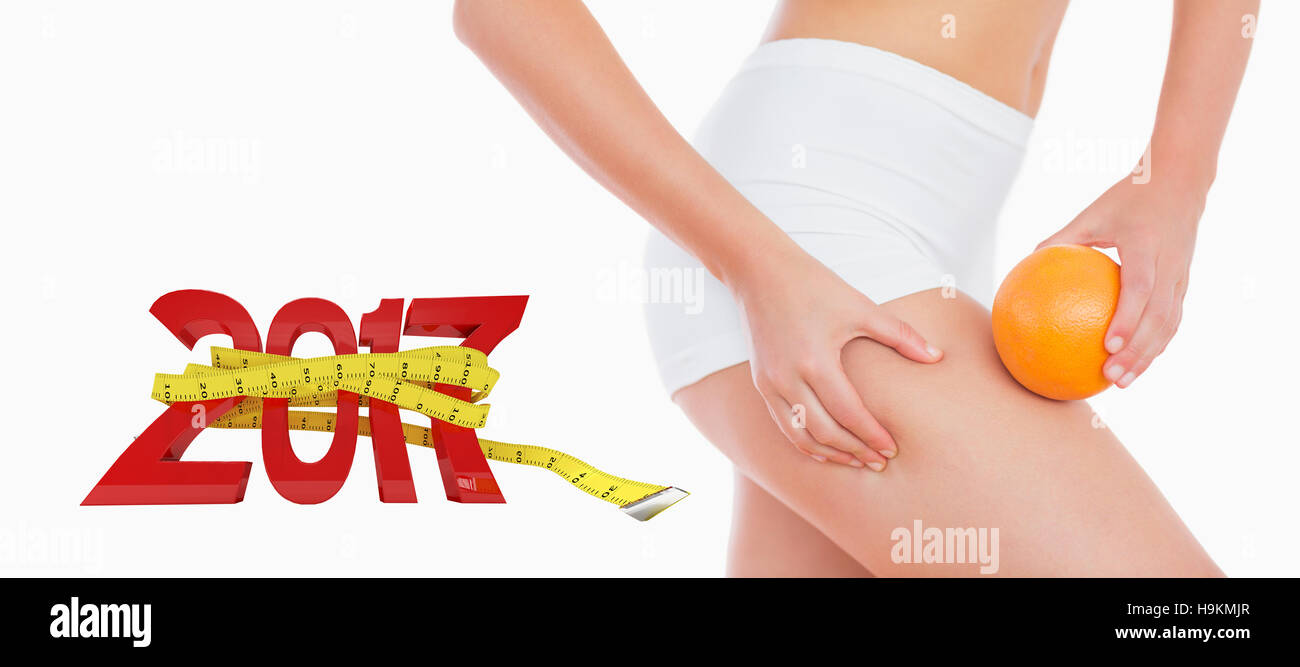 3D'immagine composita della donna la spremitura di grasso sulla coscia che tiene arancione Foto Stock